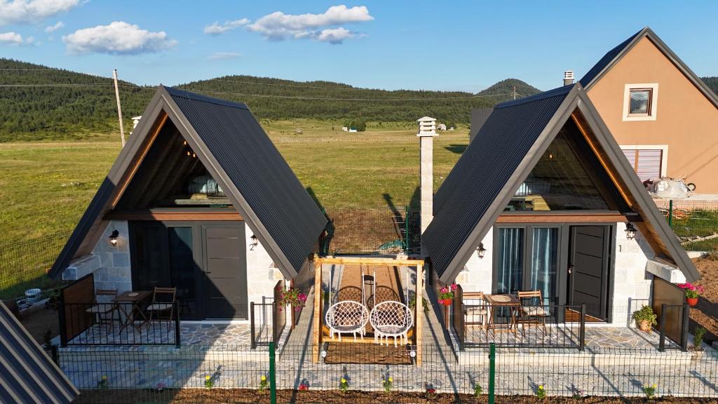a house with a pitched roof with chairs on a patio at Etno House Dragas in Njegovuđa