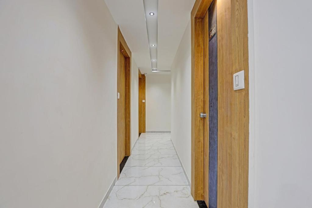 a hallway with a door and a tile floor at Hotel O Max Inn in Ahmedabad