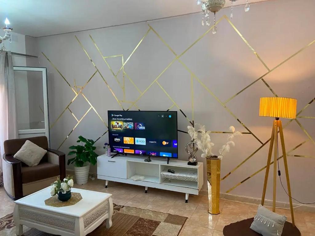 a living room with a flat screen tv on a wall at Appartement F3 équipé lux in Skikda