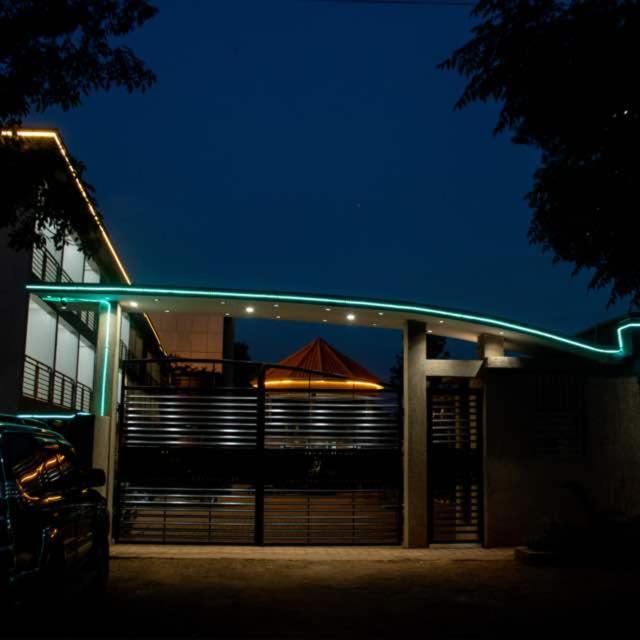 a building with a patio with an umbrella on it at night at Spark Africa Hotel in Jinja