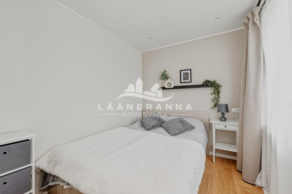 a white bedroom with a bed and a desk at Sweet apartament in Haapsalu
