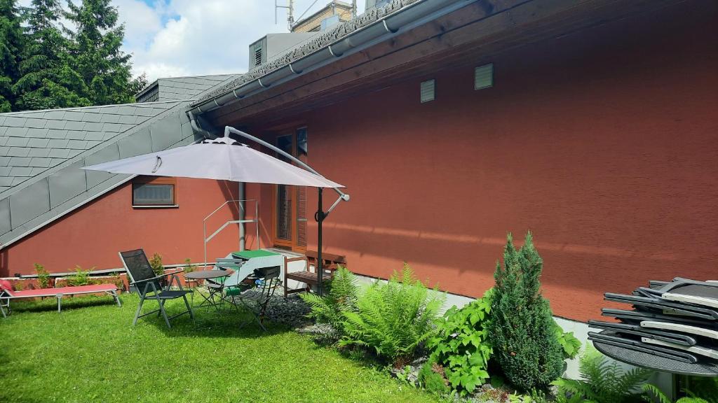 a patio with a table and an umbrella next to a building at Horský Apartmán Ramzová in Ramzová