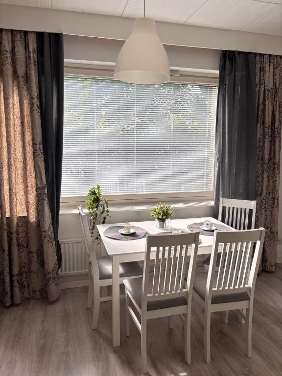 a dining room with a table and chairs and a window at Hamina Comfort Apartment in Hamina