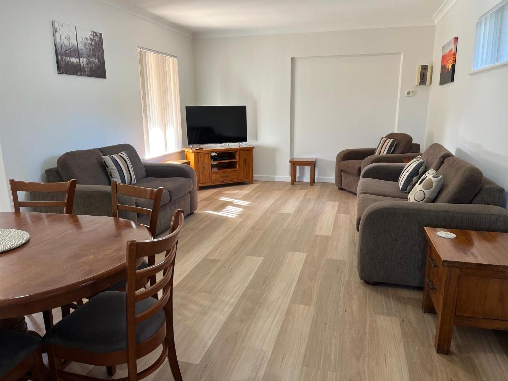 a living room with a couch and a table at Coranda Lodge in Armadale