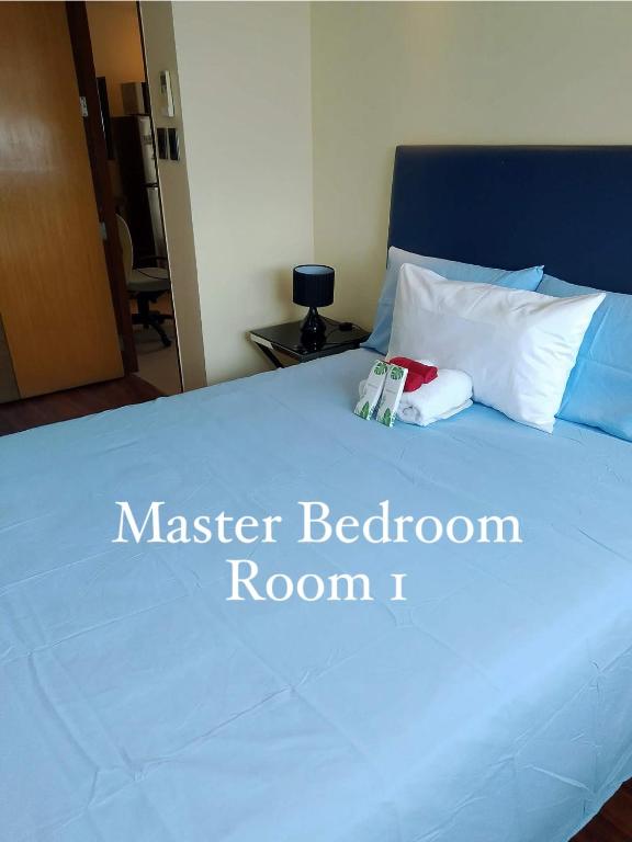 a bedroom with a bed with a blue mattress and white pillows at R2 condotel 2BR Santorini tower in Cainta