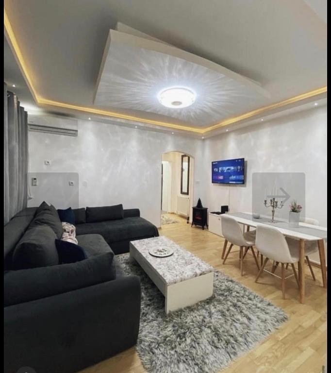 a living room with a black couch and a table at Apartman Ika in Belgrade