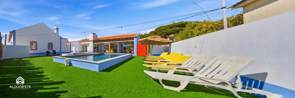 a group of chairs sitting on the grass by a pool at OceanLand - Santa Cruz in Santa Cruz