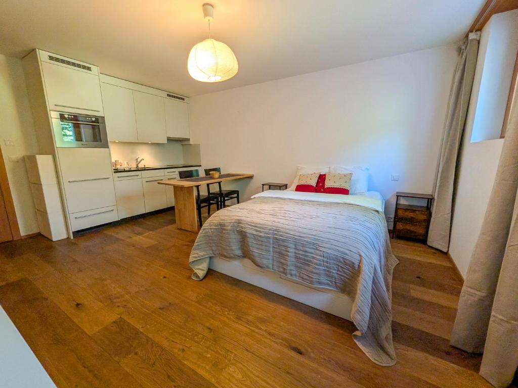 a small bedroom with a bed and a kitchen at PlanB Stay in Silvaplana