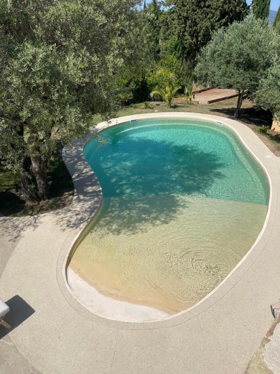 a large pool of water with trees around it at La Bernarde in Tourrettes