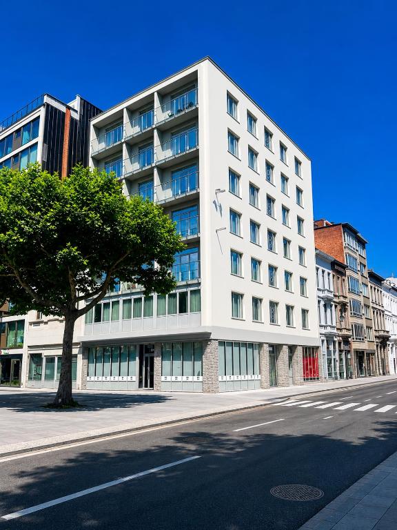 a white building on the side of a street at Roxi Roosevelt in Antwerp
