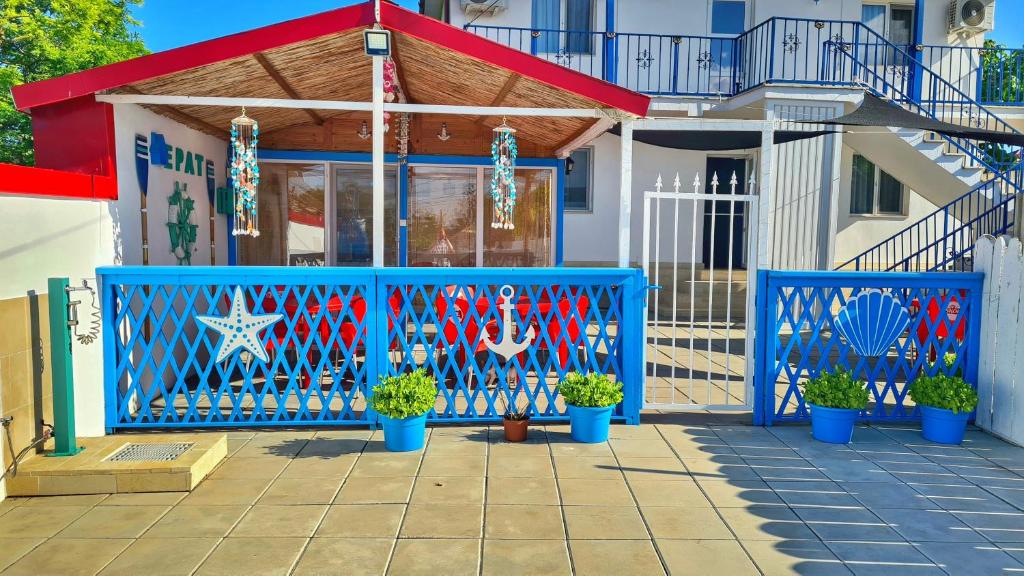 a blue gate in front of a house with potted plants at Casa Epat in 2 Mai