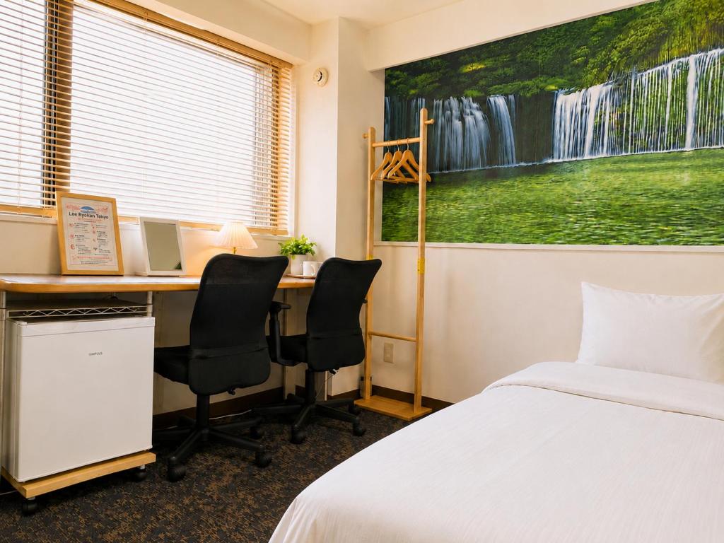 a bedroom with a desk and a bed and a desk at Lee Ryokan Tokyo in Tokyo