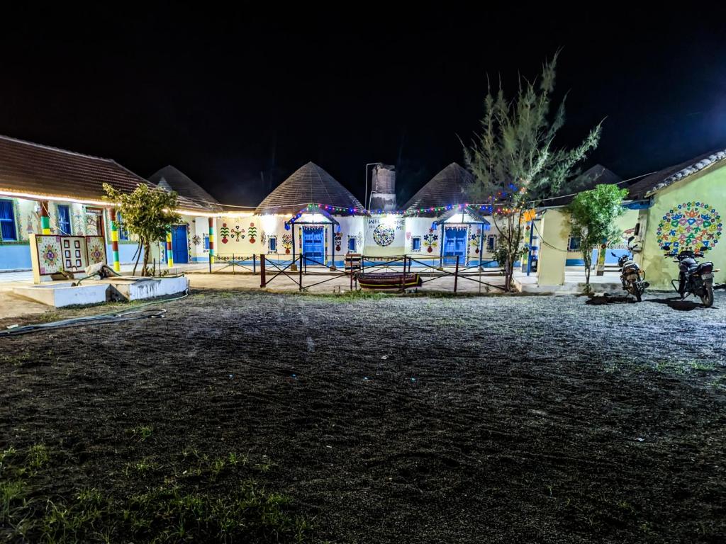 a house lit up at night with lights at White Land Village Stay in Dhordo