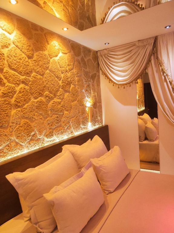 a bedroom with a bed with white pillows at GLS Priamos in Piraeus