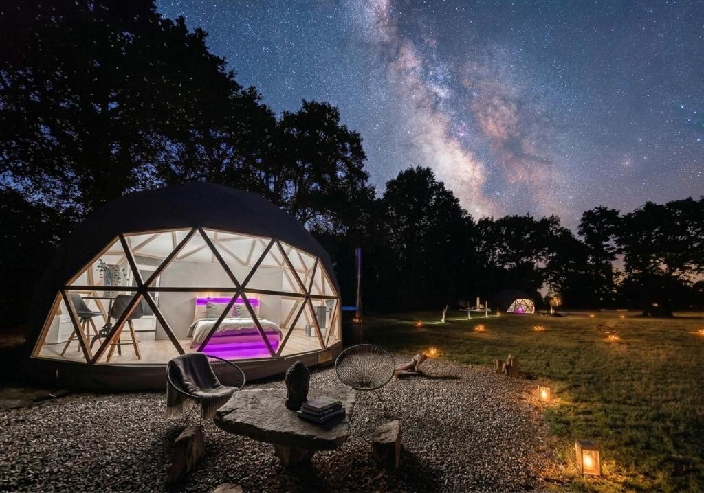 a tent with a bed in it at night at Dôme Diem luxe climatisé in Lesterps