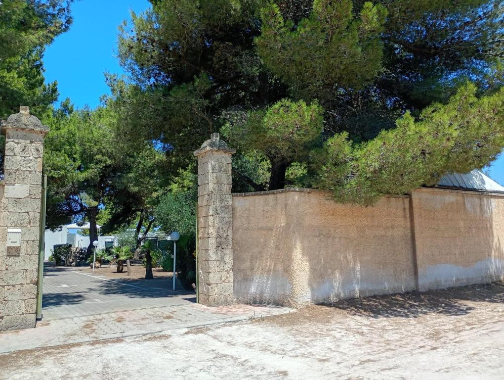 a brick wall with a tree behind it at Le casette Punta Pizzo in Gallipoli