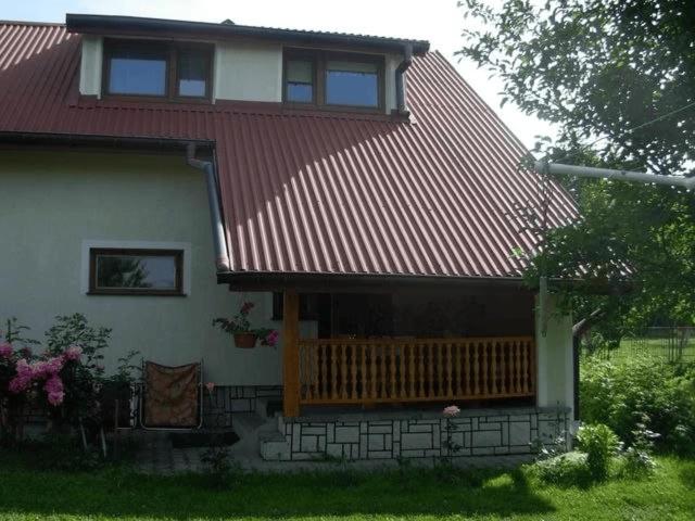 a house with a red roof and a porch at Agroturystyka u Jasienka in Mrukowa