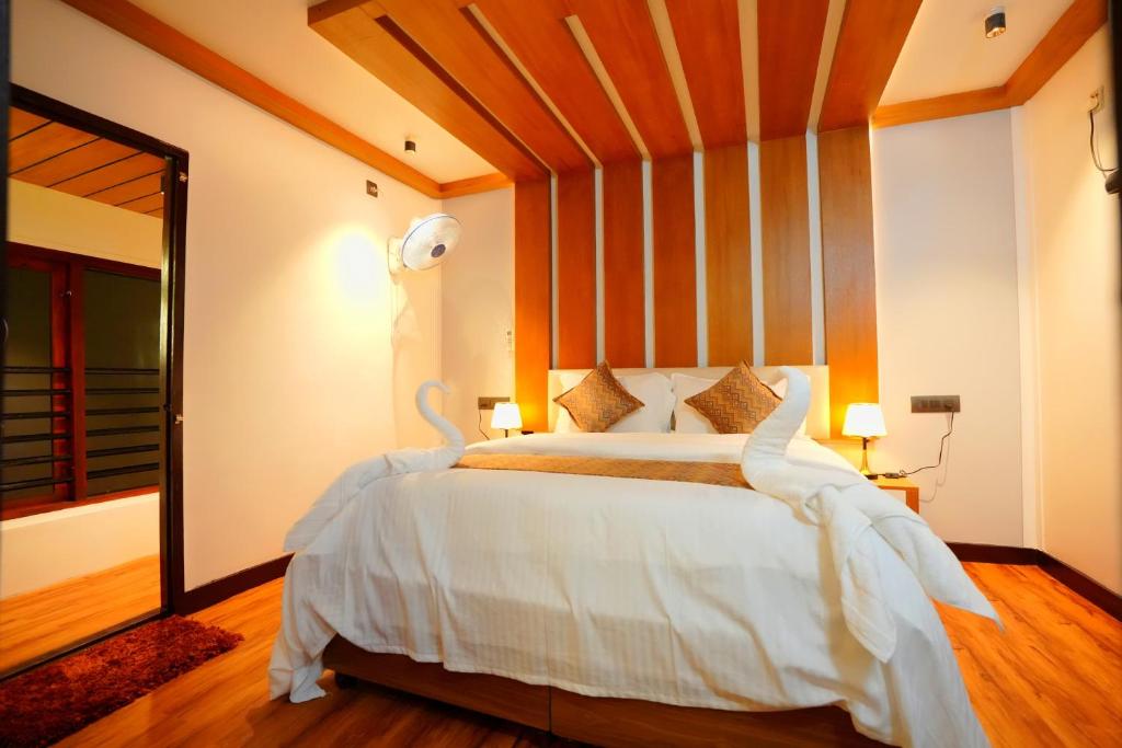 a bedroom with a large white bed with a large mirror at Boats N Beds - Alleppey Houseboats - Alleppey Boat House - Luxury Premium Houseboats in Alleppey