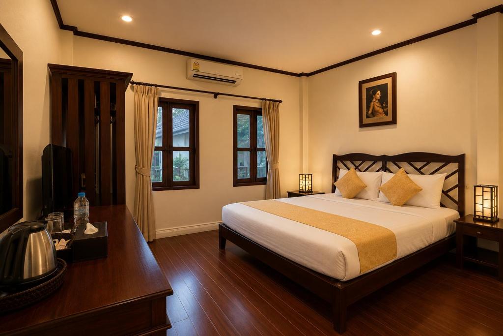 a bedroom with a bed and a television in it at Luang Prabang Legend Hotel in Luang Prabang