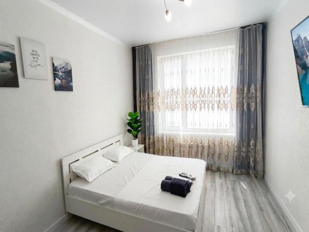a bedroom with a white bed and a window at Grand Angleterre Penthouse in Astana