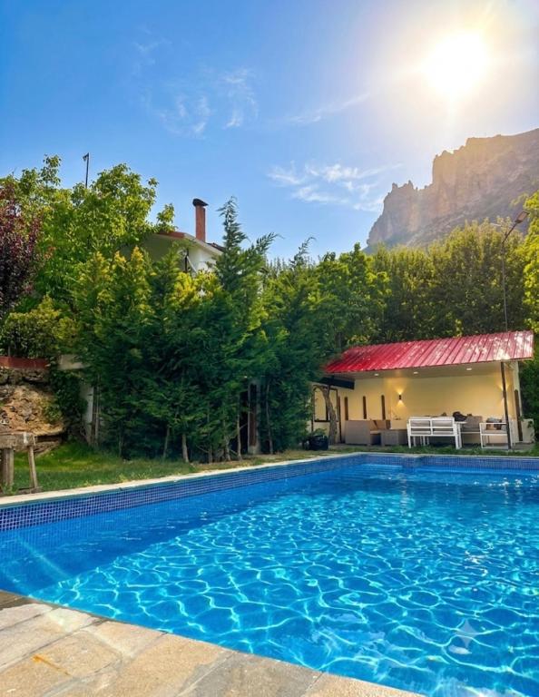 ein Swimmingpool vor einem Haus mit Bergen im Hintergrund in der Unterkunft Arida farm in Bischarri
