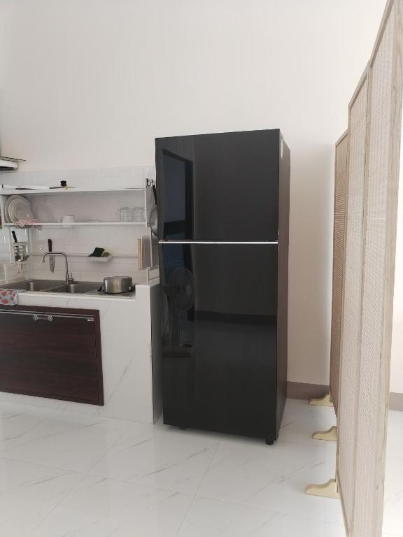 ein schwarzer Kühlschrank in einer Küche mit Spüle in der Unterkunft TamApartment in Ko Phangan