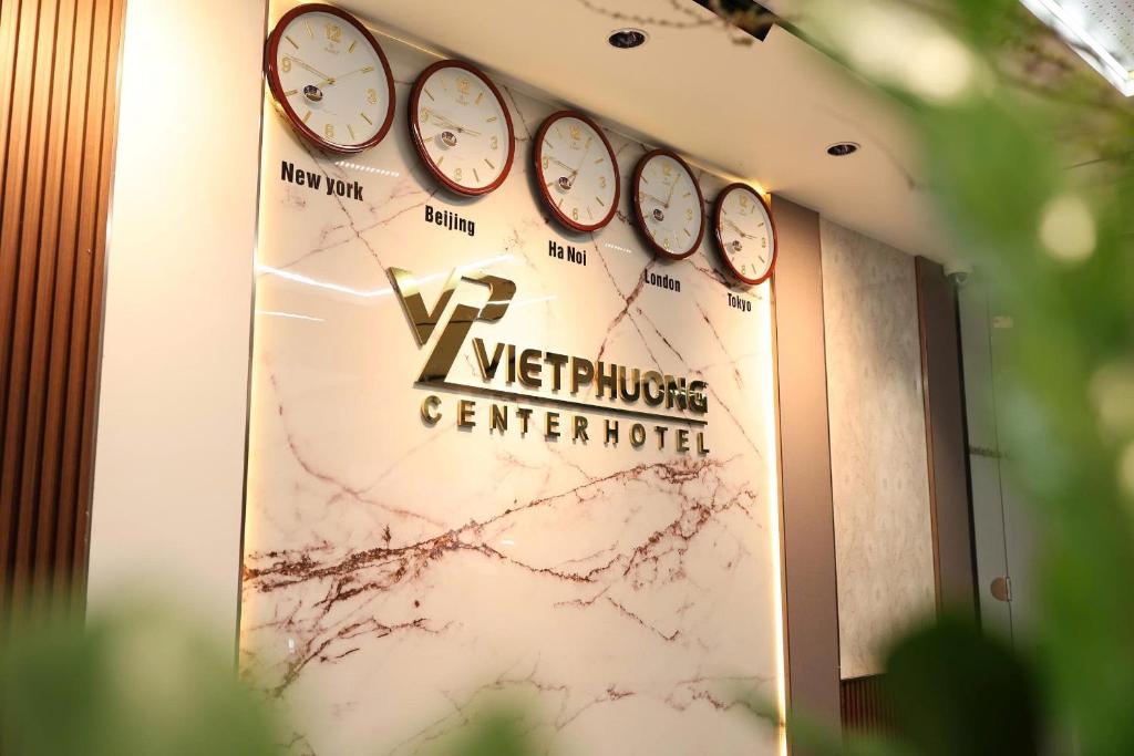 a sign with four clocks on a wall at Viet Phuong Center Hotel in Ninh Binh