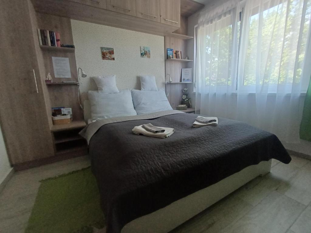 a bedroom with a bed with two towels on it at Harmónia Apartman Balatonföldvár in Balatonföldvár