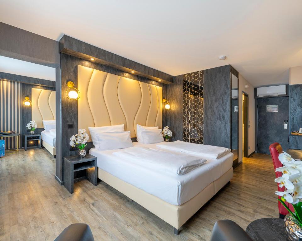 a bedroom with a large white bed in a room at PLAZA INN Bruchsal in Bruchsal