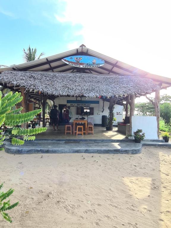 a restaurant on the beach with a table and chairs at Kanthans Lighthouse Cabanas in Komari