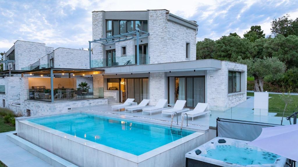 a house with a swimming pool in the backyard at Alessandra Luxury Villas with Private Pools and Jacuzzi in Kriopigi