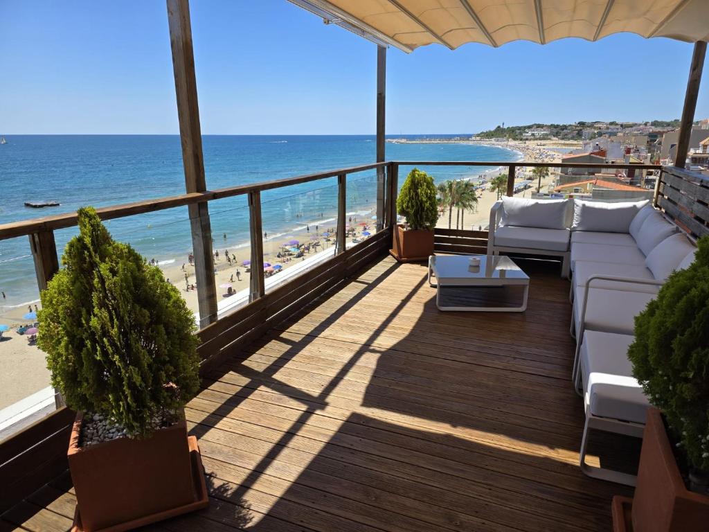 a balcony with a couch and a view of the beach at Apartamentos Wundermar in Torredembarra