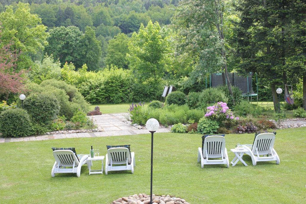 Landhotel Hubertus في Unterelsbach: مجموعة من الكراسي جالسة على العشب