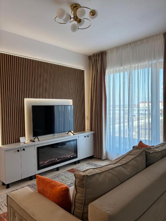 a living room with a couch and a flat screen tv at Oasis-First Estates Pipera in Voluntari