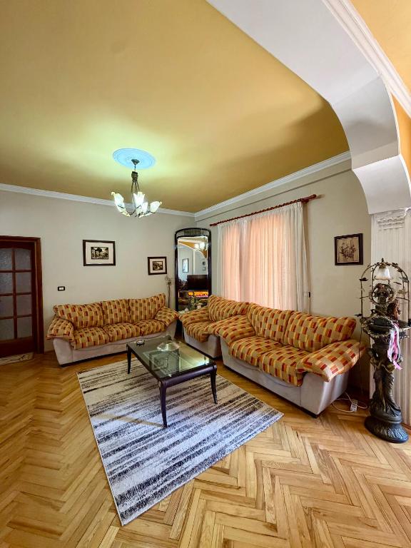 a living room with two couches and a table at Shkodra Central in Shkodër