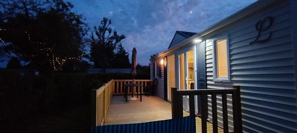 a porch of a house with a wooden deck at vent de liberté 80 camping les peupliers in Vironchaux