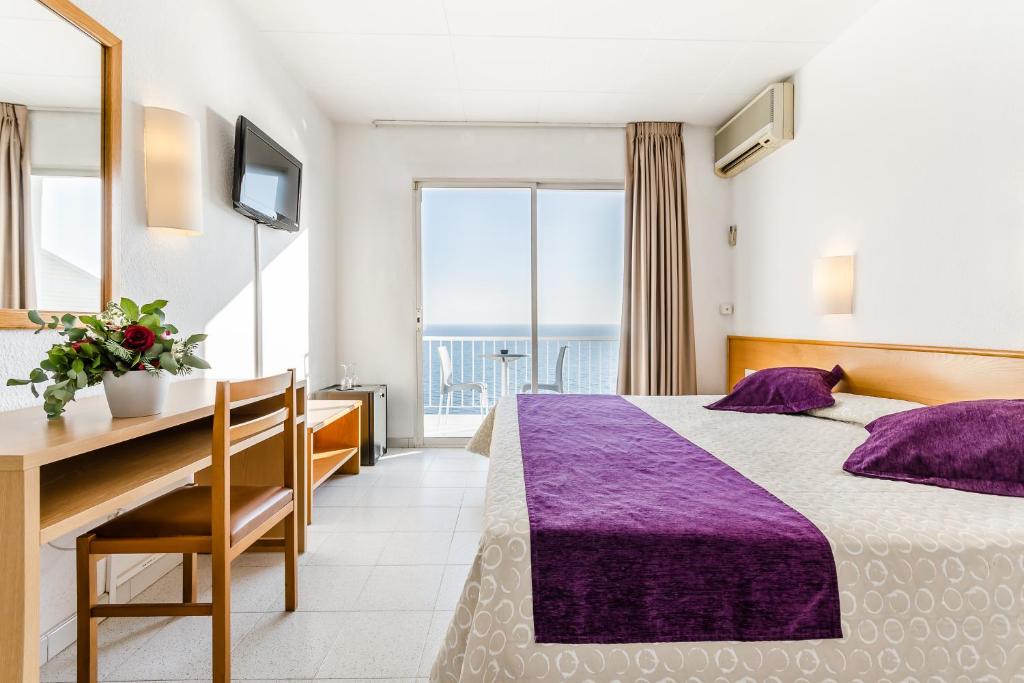サン・ポル・デ・マールにあるグラン ソル ホテルのベッドとデスクが備わるホテルルームです。