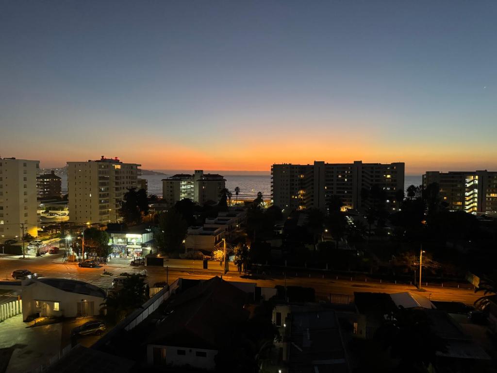a view of a city at night with the ocean at Moderno departamento cercano a playa in La Serena