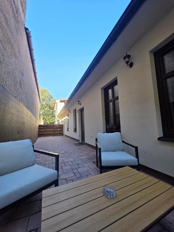 a patio with two chairs and a wooden table at Apartmán Gabriel in Kežmarok