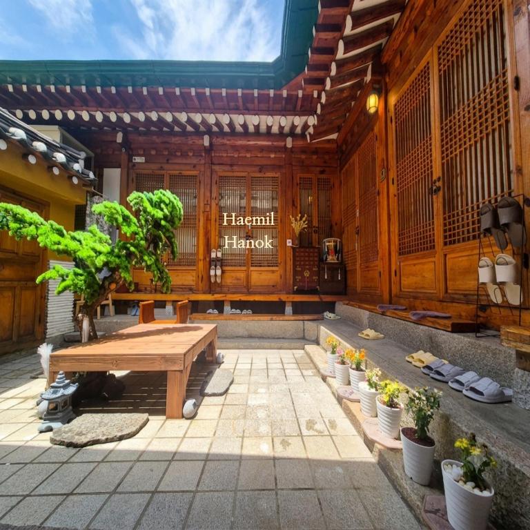 a wooden building with a picnic table and potted plants at HAEMIL Hanok 해밀한옥 in Seoul