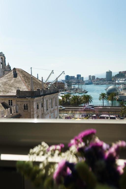 a view of a harbor from a window with flowers at The Seven Mansions in Genoa