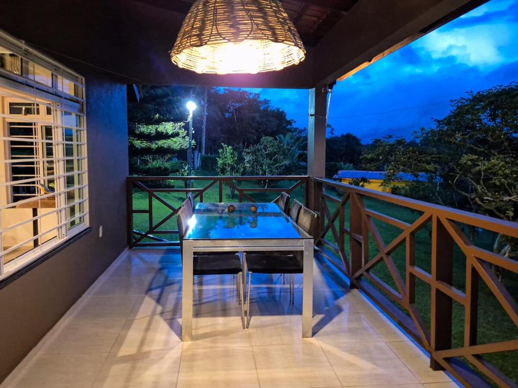 a room with a table on a balcony at night at Sítio Quinta da Serra in Guaramiranga