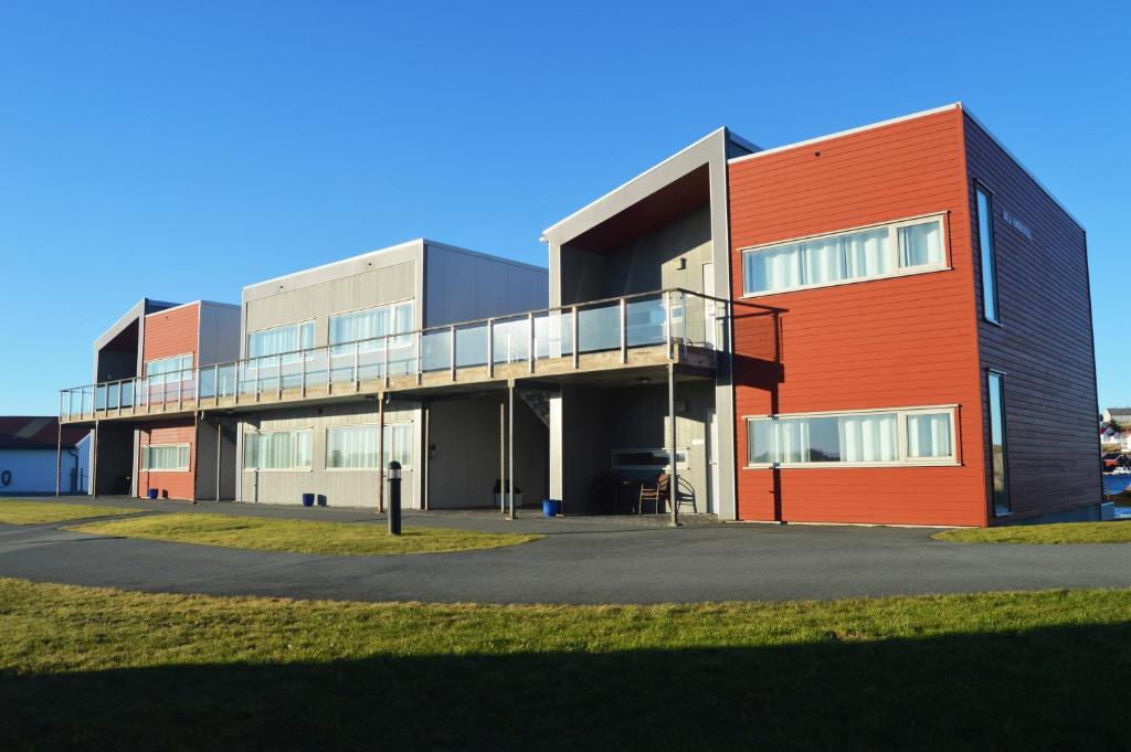 een groot gebouw met een oranje en zwart bij Sula Rorbuer og Havhotell in Sula