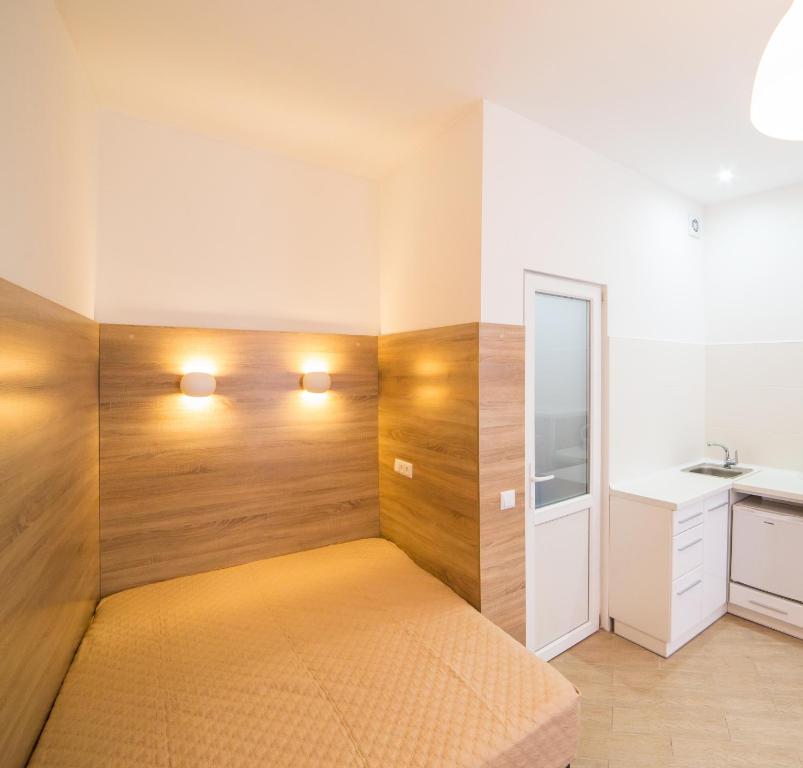 リヴィウにあるMini Apartment on Kulisha 29-3の木製の壁のベッドルーム1室(ベッド1台付)