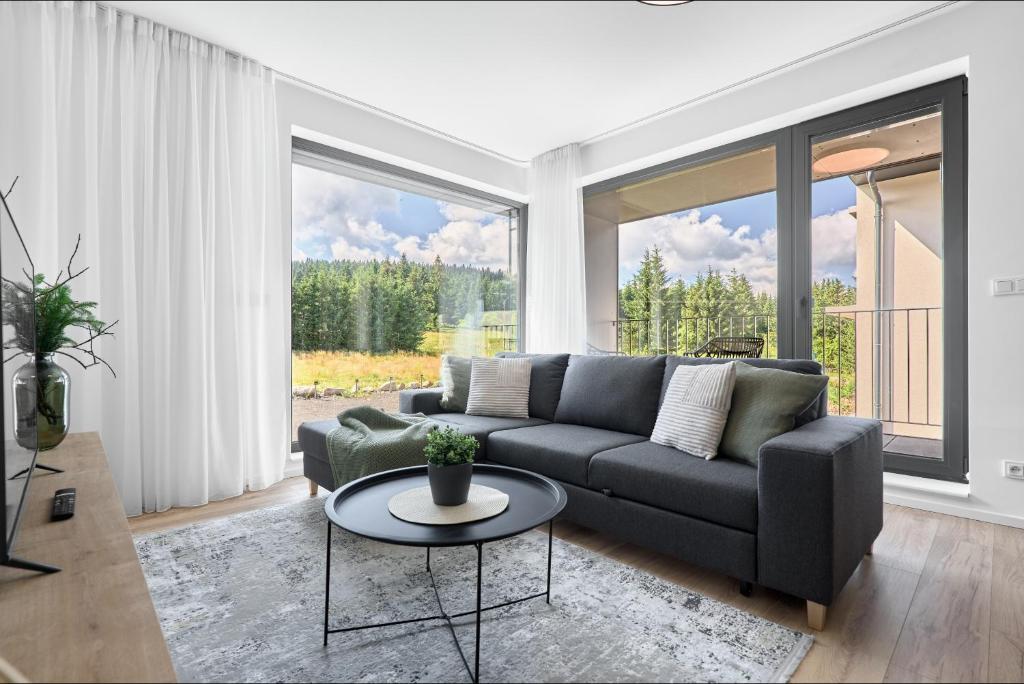 a living room with a couch and a table at Apartmány Krušec by Mountain ways in Plešivec