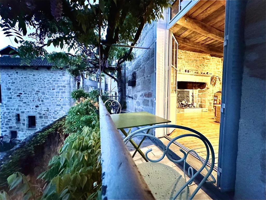 a patio with a table and bench on a balcony at Le Soleilho in Figeac