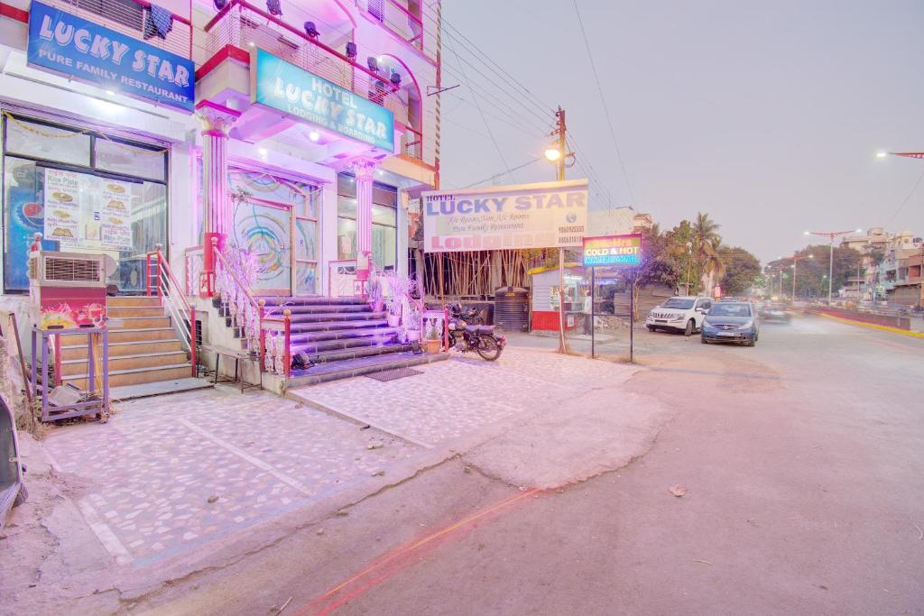 a building with neon lights on a city street at 6 CR Hotel Lucky Star CENTRAL BUS STOP in Aurangabad