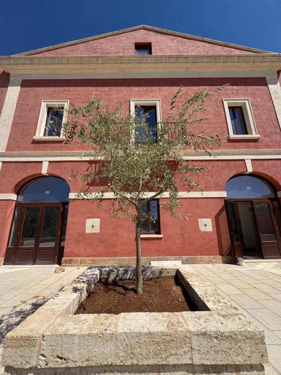 a tree in front of a red brick building at Villa ArboreA in Squinzano