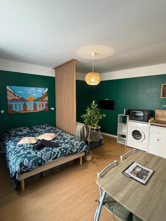 a bedroom with a bed and a table in it at Studio cosy - inspiré de Capri in Bar-le-Duc