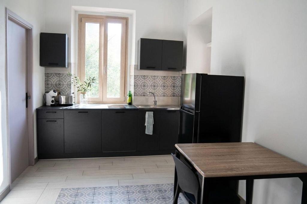 a kitchen with a black refrigerator and a table at Il club degli scacchi in San Lorenzo del Vallo